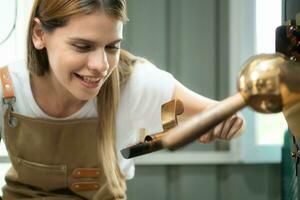 retrato do uma jovem mulher trabalhando com uma café torrador máquina foto