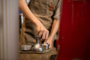 fechar-se do barista mãos usando portafilter para fazer café expresso. foto