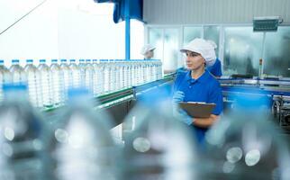 bebendo água fábrica trabalhador às uma Produção linha do bebendo água fábrica foto