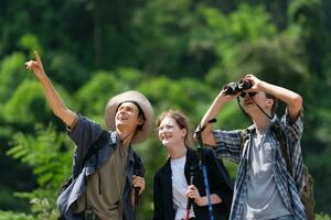 grupo do turistas com mochilas caminhando em a trilha dentro a rio e montanhas foto