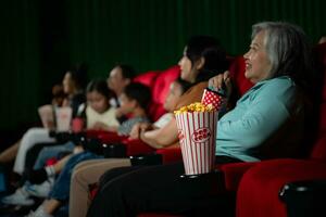 ásia mãe e filha assistindo filme dentro cinema. família Tempo conceito. foto