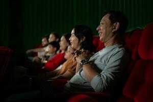 ásia mãe e filha assistindo filme dentro cinema. família Tempo conceito. foto