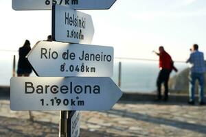 placa indicando a direção e distâncias dentro quilômetros para alguns importante cidades dentro a mundo para exemplo Barcelona foto