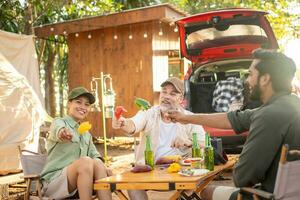 grupos de turistas bebendo cerveja-álcool e tocando violão junto com diversão e felicidade no verão enquanto acampam foto