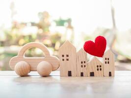 miniatura casa, vermelho coração e de madeira brinquedo carro. conceito do família foto
