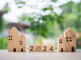de madeira quadra com 2024 e objetivo o negócio ícone com miniatura casa. propriedade investimento, casa hipoteca, real este, família conceito foto
