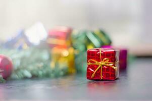 close-up da caixa de presente de artesanato com fita vermelha na mesa de madeira para fundo de decoração de natal ou ano novo foto