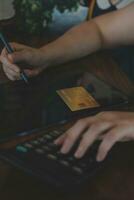fechar a mão do empresário usando a calculadora e trabalhando com laptop calcular sobre contabilidade financeira no coffeeshop outdor.conceito de contabilidade financeira foto