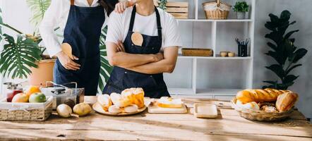 feliz jovem adulto casal fazer café da manhã e bebendo café juntos dentro acolhedor casa cozinha dentro manhã às lar. preparando refeição e sorridente. estilo de vida, lazer e amor conceito. foto