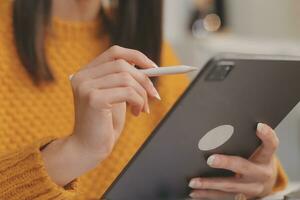 cortada foto do trabalhador autonomo o negócio ásia mulher segurando café copo e às fazendo planejamento analisando a financeiro relatório, o negócio plano investimento, finança análise a ambiente de trabalho.