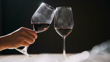 conjunto de mãos segurando um copo de vinho tinto isolado no fundo preto. foto