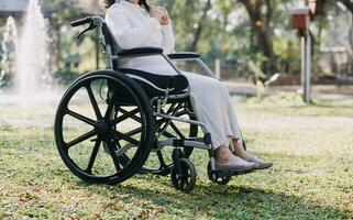 ásia jovem mulher enfermeira às enfermagem casa levar Cuidado Desativado Senior cara. cuidador médico servir fisica terapia para Mais velho idosos paciente para exercício e prática caminhando em andador ou bengala às quintal. foto