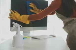 escritório limpeza serviço. zelador pulverização escrivaninha. local de trabalho higiene foto