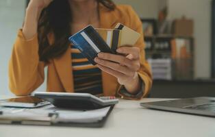 mulheres segurando crédito cartão e usando smartphones às casa.online compras, Internet bancário, loja on-line, pagamento, gastos dinheiro, comércio eletrônico Forma de pagamento às a loja, crédito cartão, conceito foto