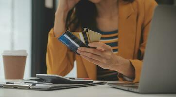 mulheres segurando crédito cartão e usando smartphones às casa.online compras, Internet bancário, loja on-line, pagamento, gastos dinheiro, comércio eletrônico Forma de pagamento às a loja, crédito cartão, conceito foto