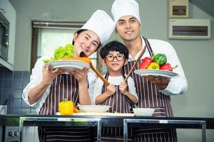 mulher asiática jovem mãe com filho menino cozinhando foto