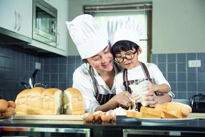 mulher asiática e menino usando óculos cozinhando foto