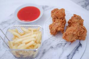 francês fritas, frito frango e ketchup em branco mármore mesa. foto