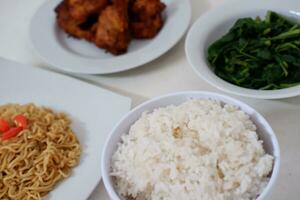 instante macarrão com frito frango e arroz em branco prato foto