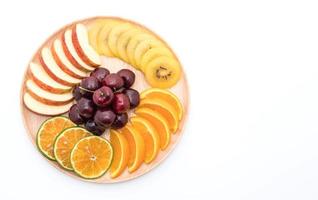 Misto de frutas fatiadas em prato de madeira foto
