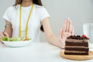 corpo feminino magro de beleza confunde bolo de chocolate. mulher em restaurante atinge meta de emagrecimento para vida saudável, louca por magreza, cintura fina, nutricionista. dieta, forma do corpo. foto