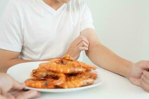 Comida alergias, homens ter reações comichão e vermelhidão depois de comendo camarão, frutos do mar alergia, coceira, irritação na pele, abdominal dor, diarréia, peito aperto, inconsciência, morte, forte evitar alergias foto