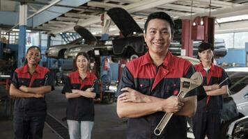 retrato do profissional trabalhadores equipe, masculino ásia Supervisor braços cruzado com fixação Ferramentas dentro frente do mecânico colegas, garantia carro reparar empregos sucesso com alegre sorrisos às serviço garagem. foto