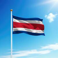 acenando bandeira do costa rica em mastro de bandeira com céu fundo. foto