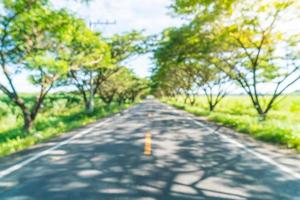 Resumo desfocar estrada de asfalto na floresta - aumentar o estilo de processamento de cores com efeito sunflare foto