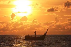 um pescador está orando com um lindo fundo de pôr do sol