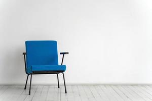 cadeira azul em um fundo de parede branca em uma sala vazia