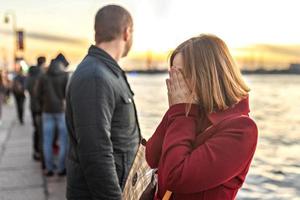 casal homem e mulher em uma briga, no aterro ao pôr do sol. foto