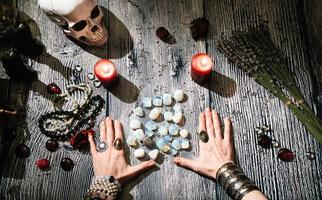mãos de adivinho com runas de pedra, interior místico.