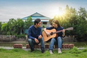 casal familiar tocando violão no jardim em casa foto