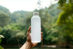 mãos segurando uma branco garrafa do soro de leite proteína em natureza fundo foto