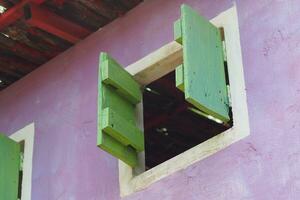 velho casa com verde e amarelo janelas foto