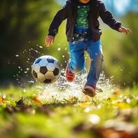 criança jogando futebol em a campo. pequeno Garoto chutando uma futebol bola. foto