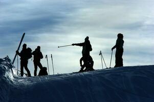 uma grupo do pessoas em pé em uma neve coberto declive foto