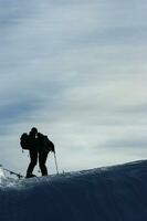 uma grupo do pessoas em pé em uma neve coberto declive foto