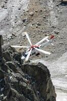 uma helicóptero é vôo sobre uma rochoso montanha foto