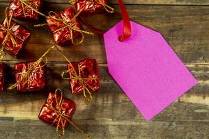 elementos decorativos de natal ao lado do cartão com fita vermelha e espaço para escrever foto