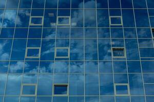 arquitetônico detalhe do a fachada com múltiplo reflexões do nublado céu e a Sol. foto