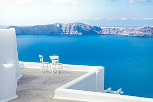 duas cadeiras no terraço com vista para o mar. ilha de santorini, grécia. fundo de viagens e férias. melhor na paisagem de viagens para casal romântico ou destino de lua de mel. localização e vista fantásticas foto