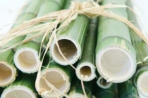 uma grupo do bambu Gravetos amarrado juntos com fio foto