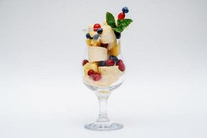 copo de salada de frutas isolado no fundo branco foto