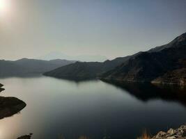 uma lindo dia Visão do wadi qanuna barragem dentro al bahá, saudita arábia. a água do a barragem e a em torno da colinas estão apresentando uma lindo cena dentro a luz solar. foto