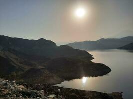 uma lindo dia Visão do wadi qanuna barragem dentro al bahá, saudita arábia. a água do a barragem e a em torno da colinas estão apresentando uma lindo cena dentro a luz solar. foto