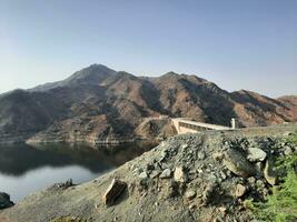 uma lindo dia Visão do wadi qanuna barragem dentro al bahá, saudita arábia. a água do a barragem e a em torno da colinas estão apresentando uma lindo cena dentro a luz solar. foto