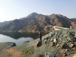 uma lindo dia Visão do wadi qanuna barragem dentro al bahá, saudita arábia. a água do a barragem e a em torno da colinas estão apresentando uma lindo cena dentro a luz solar. foto