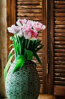 um buquê de flores suavemente focado em um vaso velho foto